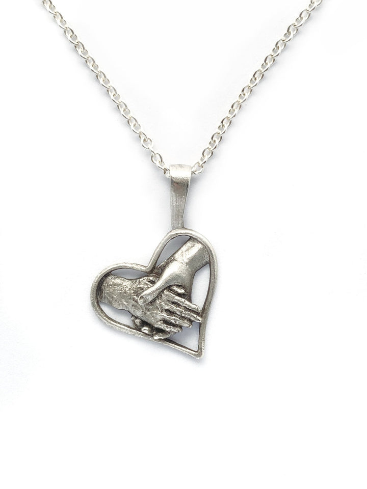 Sue Beatrice 'Elder Hand' Pendant: Hand clasping elder hand inside a heart