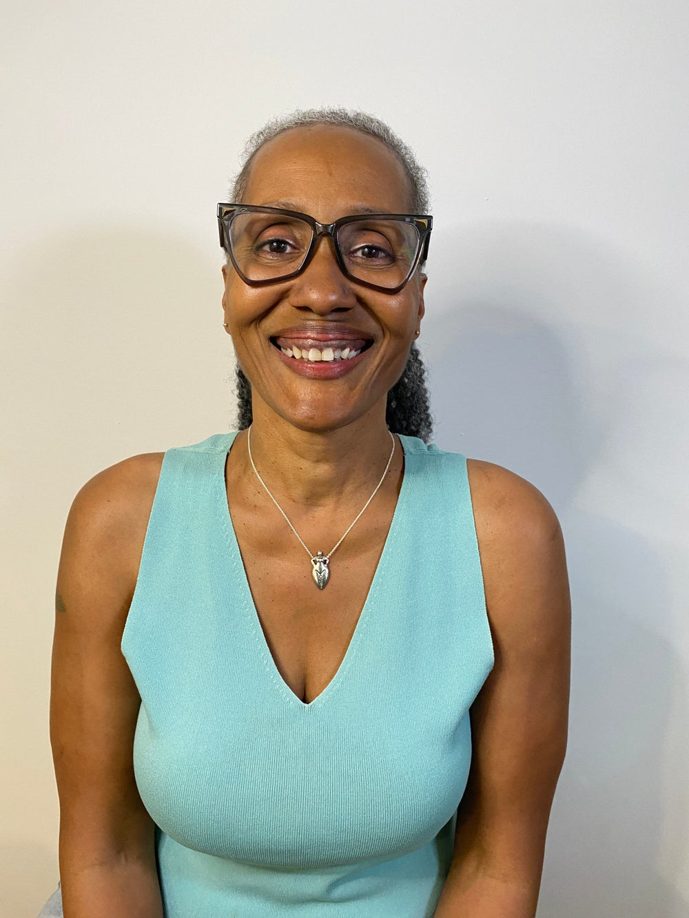 A woman with glasses wearing Silver Vote Goddess pendant on a silver chain - All Natural Arts