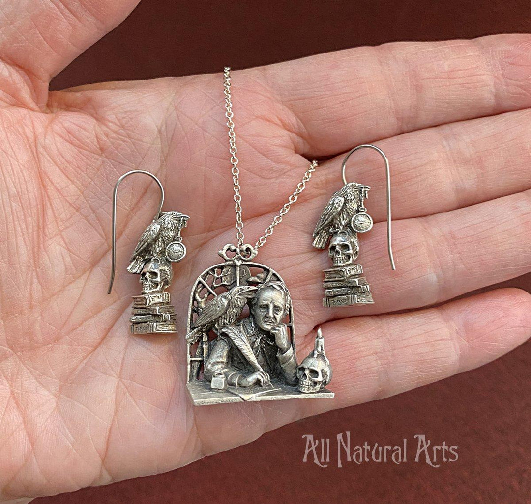 A pendant of Edgar Allal Poe sitting at a desk with matching earrings.