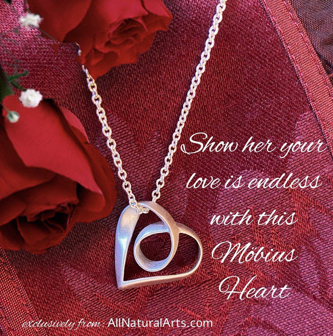 Sue Beatrice's Möbius Heart Pendant: Sterling silver necklace with infinite symbolism on red background.