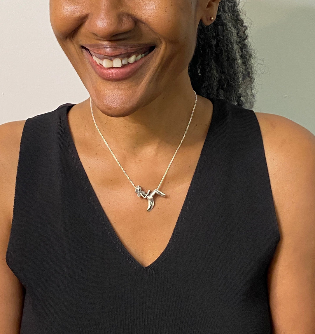 Happy woman wearing ’The Reader’ Sterling Silver Book Pendant and Necklace - Perfect for Book Lovers!