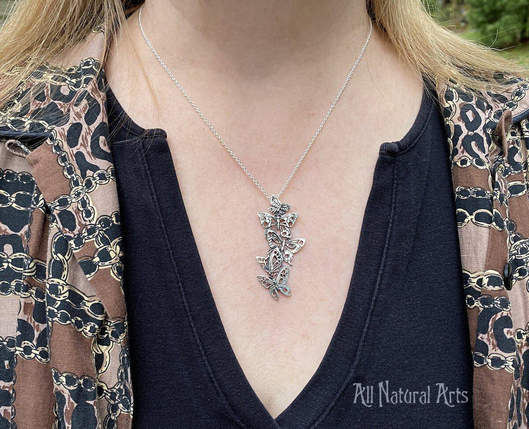 Ascending Butterflies Necklace by Sue Beatrice of All Natural Arts. Solid sterling silver filigree design with 5 ascending butterflies on an 18-inch chain worn by young woman.