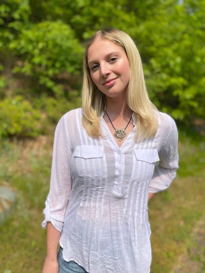 Blonde Girl in nature wearing the Enternal Embrace necklace of a pair of skeletons entwined, By Sue Beatrice