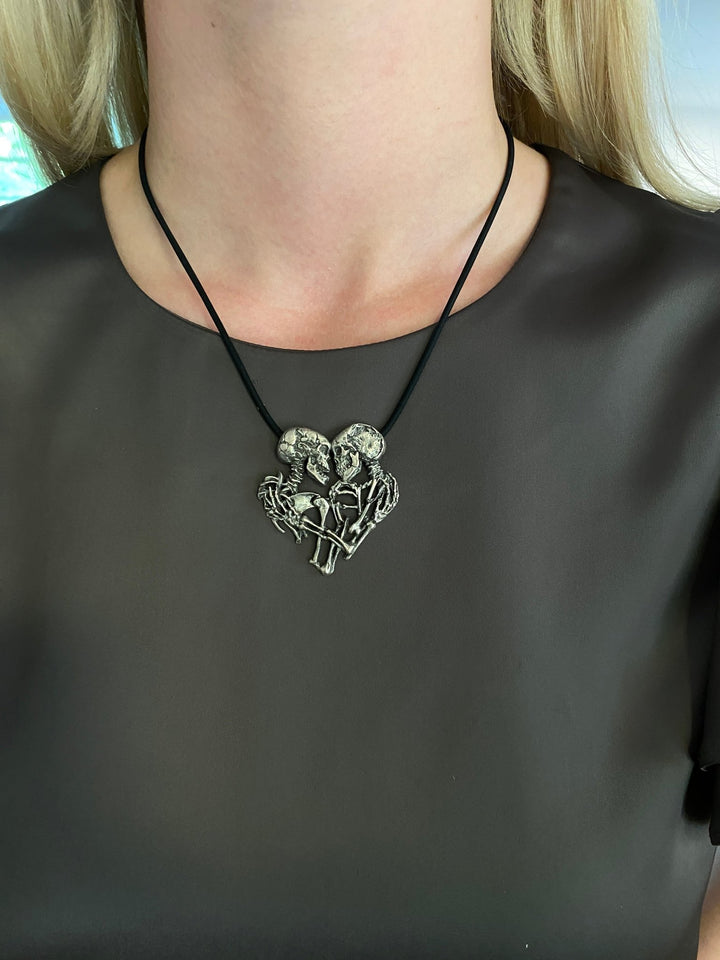 Girl wearing the Enternal Embrace necklace of a pair of skeletons entwined, By Sue Beatrice