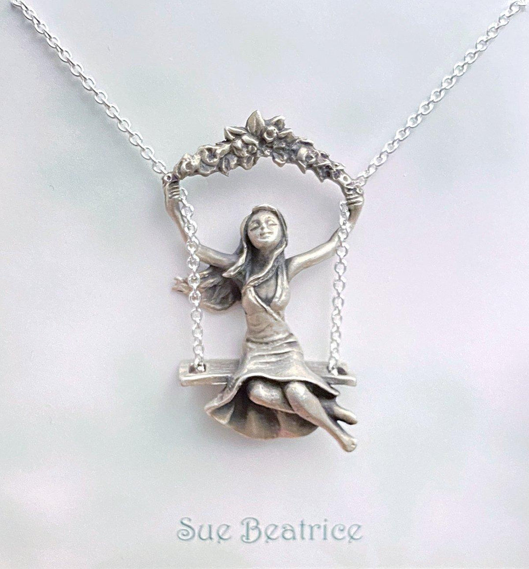 Girl on the Swing pendant on light-colored card - Sterling Silver necklace with intricate design, capturing childhood joy