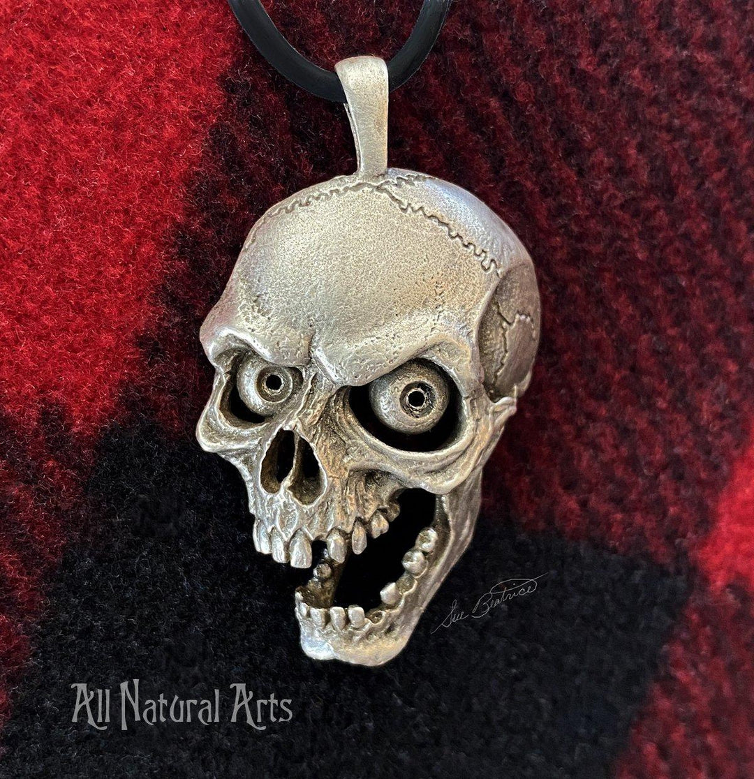 On red and black background: Screaming Skull pendant - sterling silver accessory with macabre design.