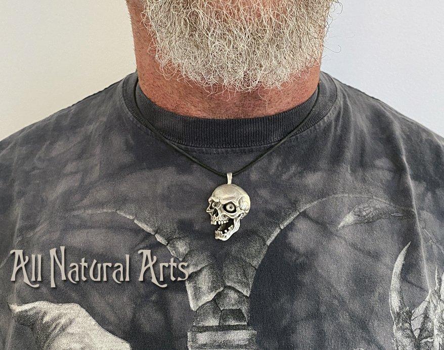 Man with beard wearing Screaming Skull pendant - silver accessory with macabre design on black cord