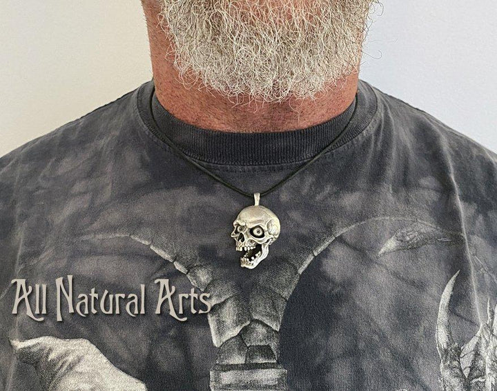 Man with beard wearing Screaming Skull pendant - silver accessory with macabre design on black cord