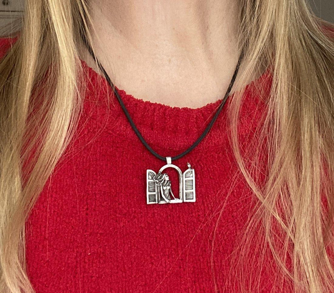 Girl wearing the Girl in the Window Necklace: Sterling silver pendant On a Black cord