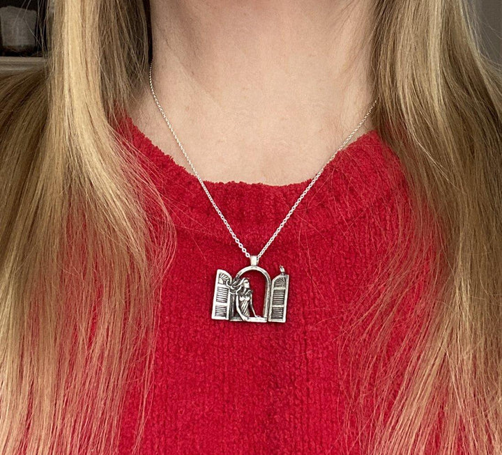 Girl wearing the Girl in the Window Necklace: Sterling silver pendant On a silver chain