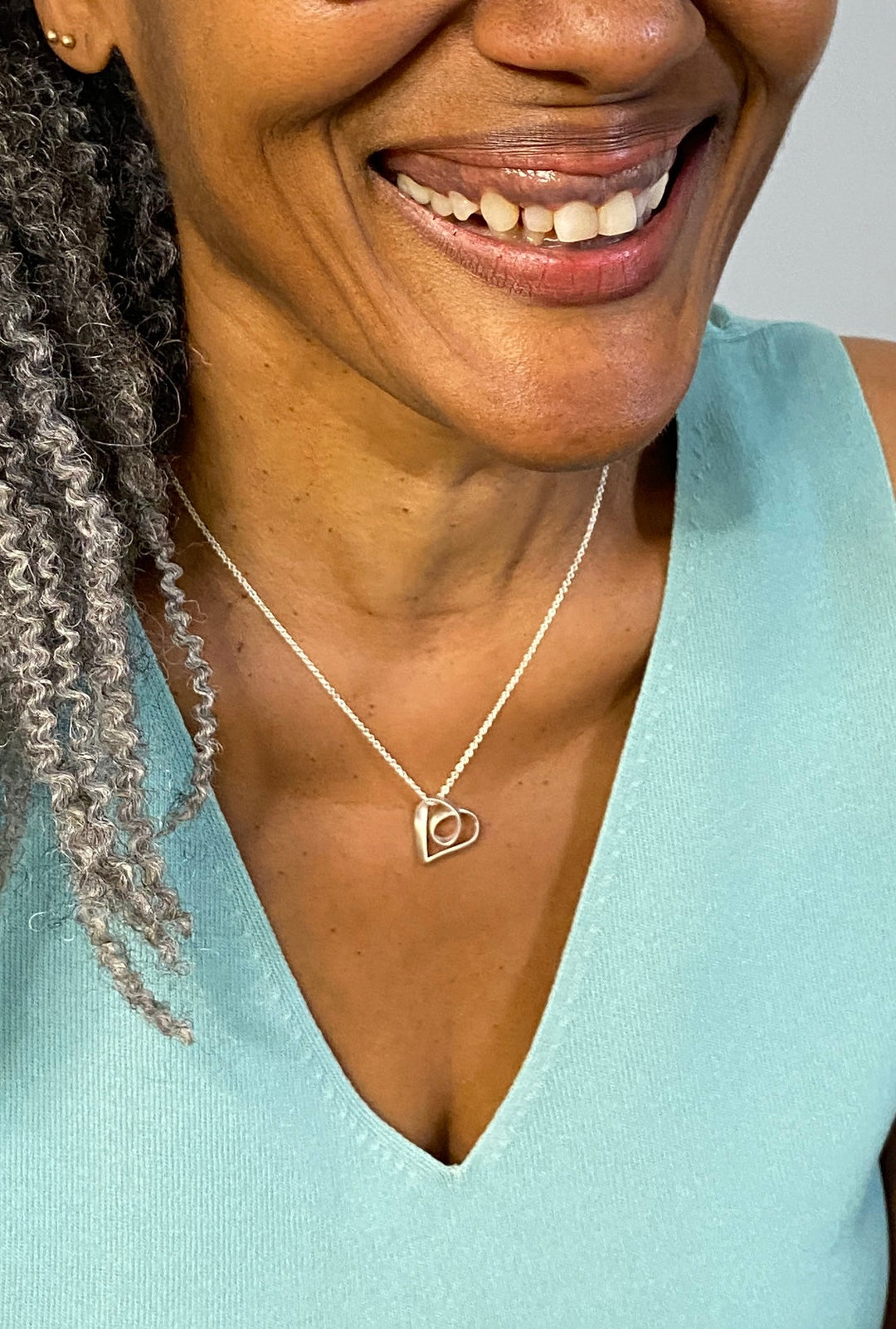 Smiling woman wearing Sue Beatrice’s Möbius Heart: Timeless Symbol of Love in Sterling Silver