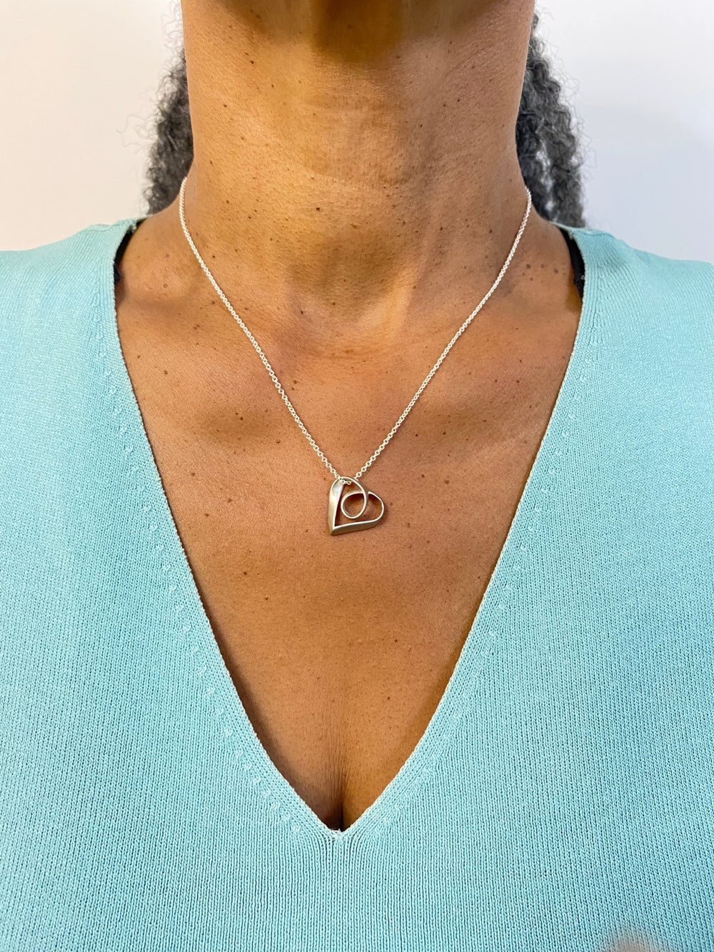Woman wearing Sue Beatrice’s Möbius Heart: Timeless Symbol of Love in Sterling Silver
