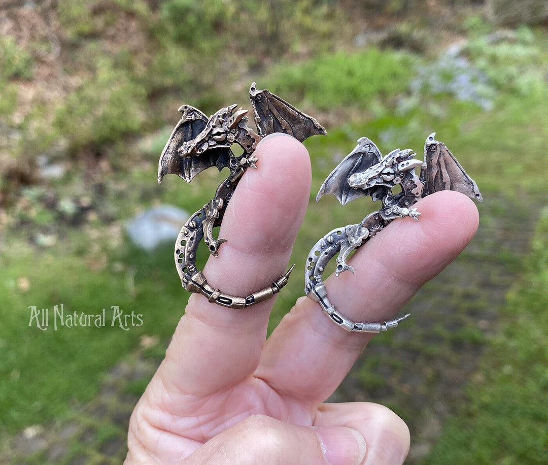 Silver and Bronze Finger Dragons perched on a fingers | Mythical jewelry that captivates the imagination.